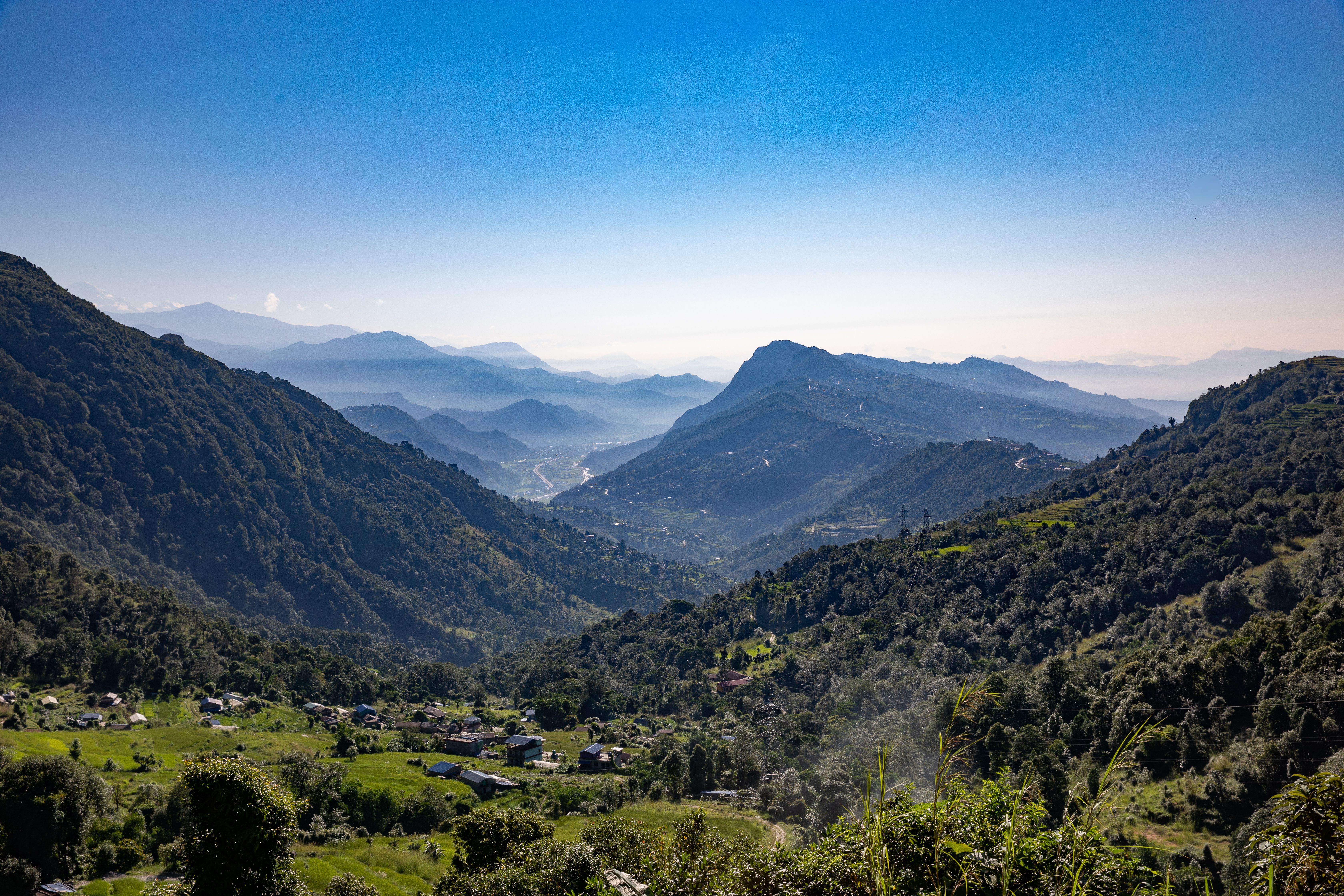 Sunrise over a Himalayan valley, a figure seated in meditation on a stone terrace